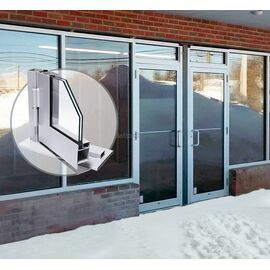 Ķieģeļu fasāde ar tērauda profila vitrīnām un durvīm. Aplī attēla malā attēlots durvju profila griezums 3D skatā ar stiklu