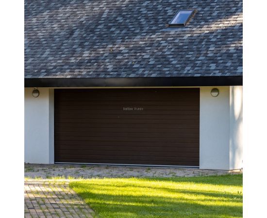 Garāžas ēka ar moderniem tumšiem sekciju garāžu vārtiem.