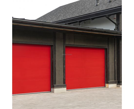 Privātmāja ar sarkaniem moderniem garāžas vārtiem, kas izceļ ēkas fasādi.